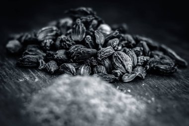 Onun toz bir ahşap yüzey üzerinde ham siyah kakule