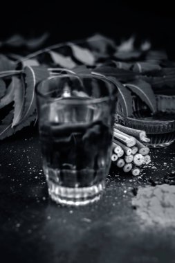 Ayurvedik tedavi için malzemeler görünümünü kapatın. Neem, neem bırakır, neem toz, ağaç kabuğu, karanfil, zerdeçal, su