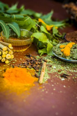 Ayurvedik tedavi için malzemeler görünümünü kapatın. Neem, neem bırakır, neem toz, ağaç kabuğu, karanfil, zerdeçal, su