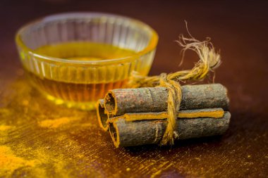 Tarçın ahşap masa üzerinde cam kapta su