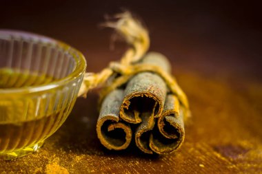 Su ahşap yüzeyde bir cam kase tarçın.