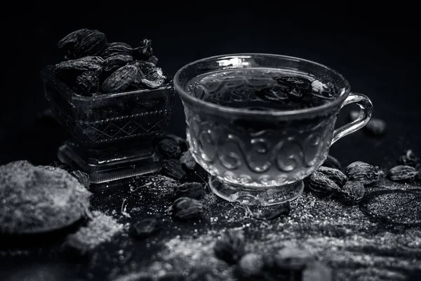 Close up view of Black cardamom tea with its powder and raw whole black cardamom