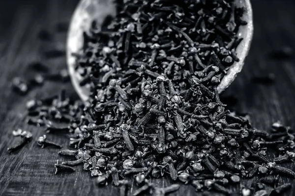 Ahşap yüzeyde bir kil kase ham organik karanfil.