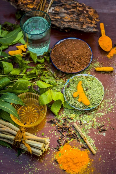 Ayurvedik tedavi için malzemeler görünümünü kapatın. Neem, neem bırakır, neem toz, ağaç kabuğu, karanfil, zerdeçal, su