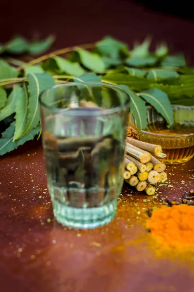 Close up view of ingredients for ayurvedic treatment. Neem, neem leaves, neem powder, bark, cloves,turmeric ,water