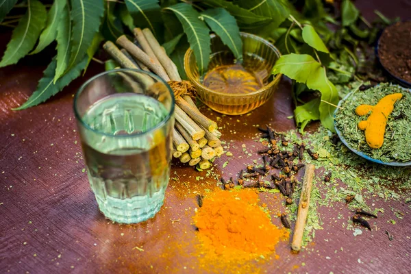Ayurvedik tedavi için malzemeler görünümünü kapatın. Neem, neem bırakır, neem toz, ağaç kabuğu, karanfil, zerdeçal, su