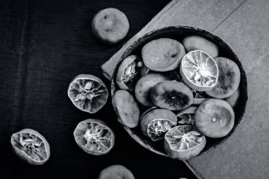 Ahşap yüzeyde paslı bir kase kuru sıkılmış limon