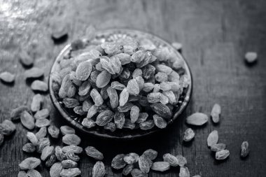 Bir cam tabakta kuru kuru üzüm görünümü bir ahşap yüzeye kadar kapatın