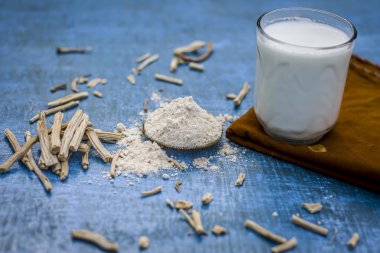 Ayurveda ot satavari tozu ve süt cam görünümünü kapat.