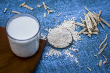 Ayurveda ot satavari tozu ve süt cam görünümünü kapat.