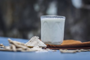 Ayurveda ot satavari tozu ve süt cam görünümünü kapat.
