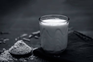 Ayurveda ot satavari tozu ve süt cam görünümünü kapat.