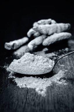 Zerdeçal ve onun toz bir ahşap yüzeye.