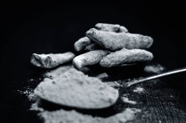 Zerdeçal ve onun toz bir ahşap yüzeye.