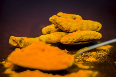 Zerdeçal kök ve onun toz bir ahşap yüzeye 