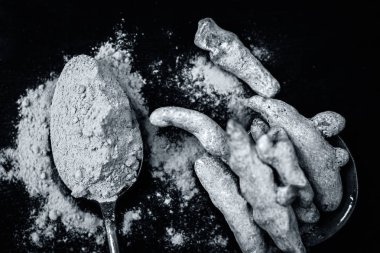 Zerdeçal kök ve onun toz bir ahşap yüzeye 