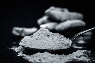 Zerdeçal kök ve onun toz bir ahşap yüzeye 