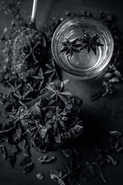 anise seeds bir bardak ve kaşık ve üzerinde ahşap yüzeyi onun tozu ile su