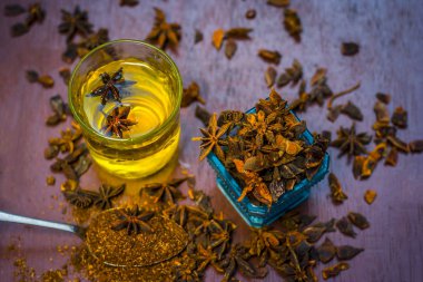 anise seeds bir bardak ve kaşık ve üzerinde ahşap yüzeyi onun tozu ile su