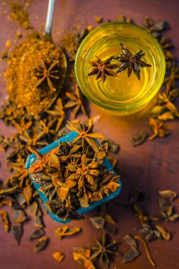 anise seeds bir bardak ve kaşık ve üzerinde ahşap yüzeyi onun tozu ile su