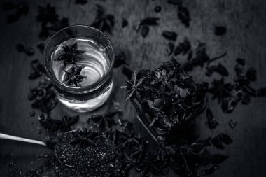 anise seeds bir bardak ve kaşık ve üzerinde ahşap yüzeyi onun tozu ile su
