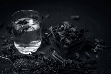 anise seeds bir bardak ve kaşık ve üzerinde ahşap yüzeyi onun tozu ile su