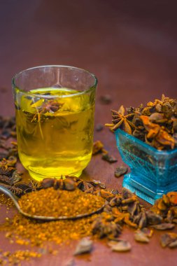 Anason baharat ve kaşık ahşap yüzey üzerinde onun tozu ile su