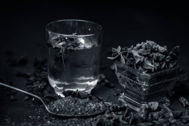 anise seeds bir bardak ve kaşık ve üzerinde ahşap yüzeyi onun tozu ile su