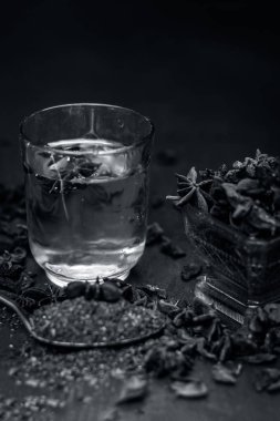 Anason baharat ve kaşık ahşap yüzey üzerinde onun tozu ile su