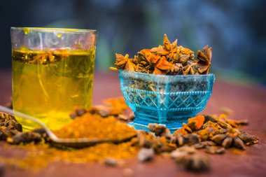 Anason baharat ve kaşık ahşap yüzey üzerinde onun tozu ile su