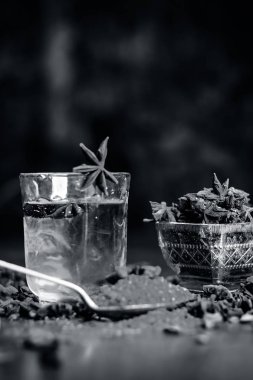 Anason baharat ve kaşık ahşap yüzey üzerinde onun tozu ile su