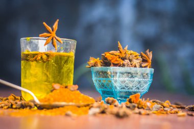 Anason baharat ve kaşık ahşap yüzey üzerinde onun tozu ile su