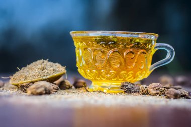 Ahşap yüzey üzerinde siyah kakule çay onun tozu ile görünümü kadar kapatın