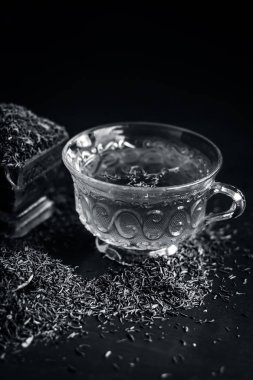 Siyah kimyon tohumu ve onun çay ahşap yüzey üzerinde 