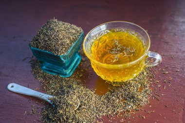 Siyah kimyon tohumu ve onun çay ahşap yüzey üzerinde 