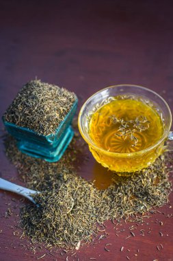 Siyah kimyon tohumu ve onun çay ahşap yüzey üzerinde 