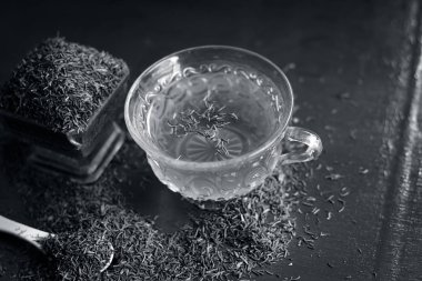 Siyah kimyon tohumu ve onun çay ahşap yüzey üzerinde 