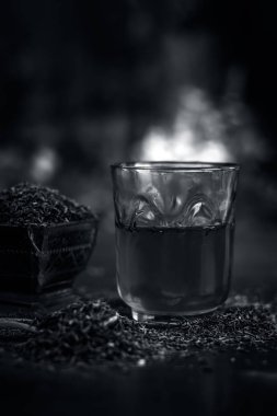 Siyah kimyon tohumu ve saydam bir cam ahşap yüzeyde ayıklanan su