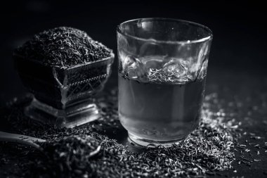 Siyah kimyon tohumu ve saydam bir cam ahşap yüzeyde ayıklanan su