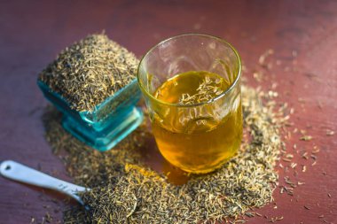 Siyah kimyon tohumu ve saydam bir cam ahşap yüzeyde ayıklanan su