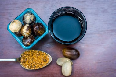 Küçük Hindistan cevizi çay, Jaiphal, bir cam kap içinde Myristica fragrans kaşık ahşap yüzey üzerinde onun tozu ile yakın çekim