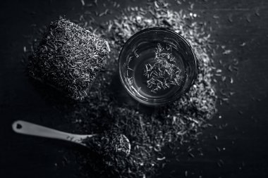 Siyah kimyon tohumu ve saydam bir cam ahşap yüzeyde ayıklanan su