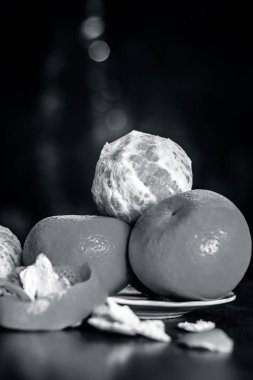 Ahşap yüzey üzerinde bir tabak içinde taze olgun mandalina, yakın çekim