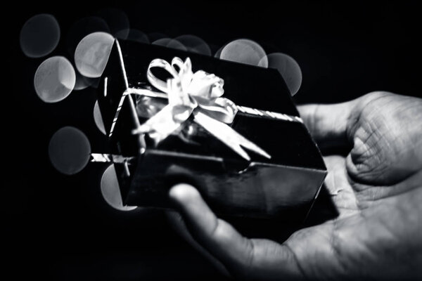 Рука с подарочной коробкой, вид из окна
