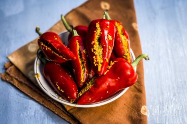 Red chilli peppers marinated in mustard seeds and mustard oil. Dark gothic style still life concept clipart
