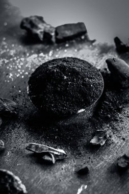 Ahşap bir yüzey üzerinde ham kömür ile kömür tozu