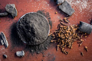 Diş macunu kömür, karanfil ve tuz, ahşap bir yüzey üzerinde sodyum klorür ile geleneksel malzemeler.