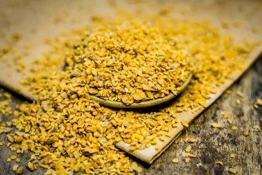 Ahşap yüzey üzerinde bir kasede ezilmiş Çemen otu tohumu