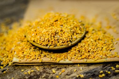 Ahşap yüzey üzerinde bir kasede ezilmiş Çemen otu tohumu