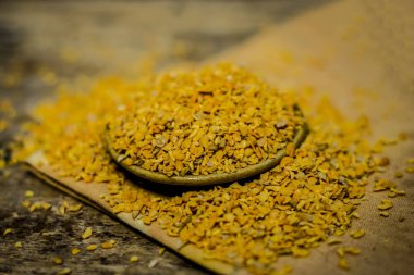 Ahşap yüzey üzerinde bir kasede ezilmiş Çemen otu tohumu